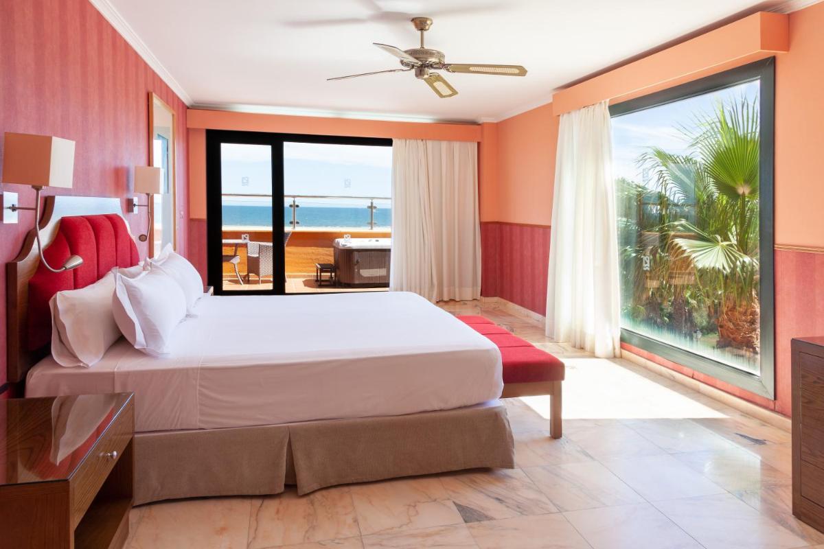 Un dormitorio con una cama y vista al mar. en Playamarina, en Isla Canela 27 fotos más
