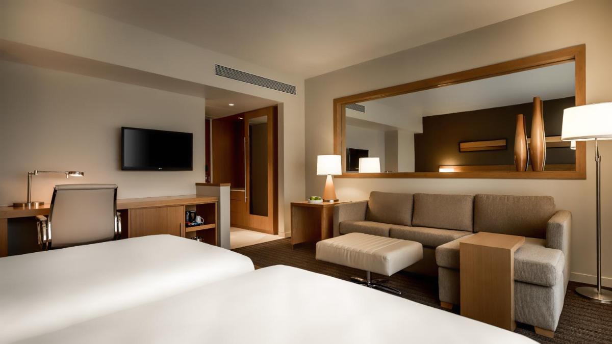 a hotel room with a bed and a couch at Hyatt Place Pune Hinjawadi in Pune