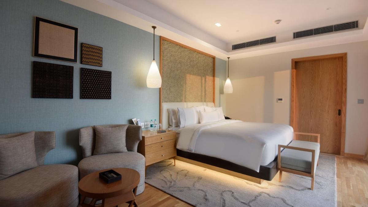 a bedroom with a bed and a couch and a chair at The Westin Resort & Spa Himalayas in Rishīkesh