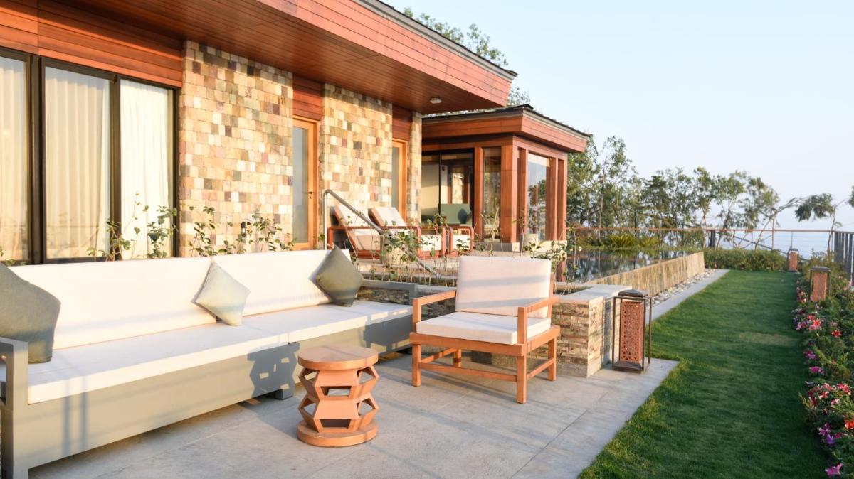 a patio with a white couch and chairs on a yard at The Westin Resort & Spa Himalayas in Rishīkesh