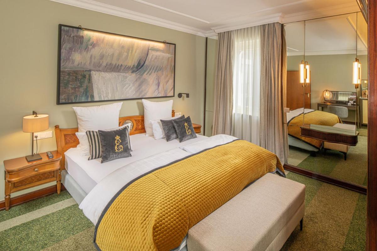 ein Schlafzimmer mit einem großen Bett mit einer gelben Decke in der Unterkunft Hotel Erbprinz - Gourmet & Spa in Ettlingen
