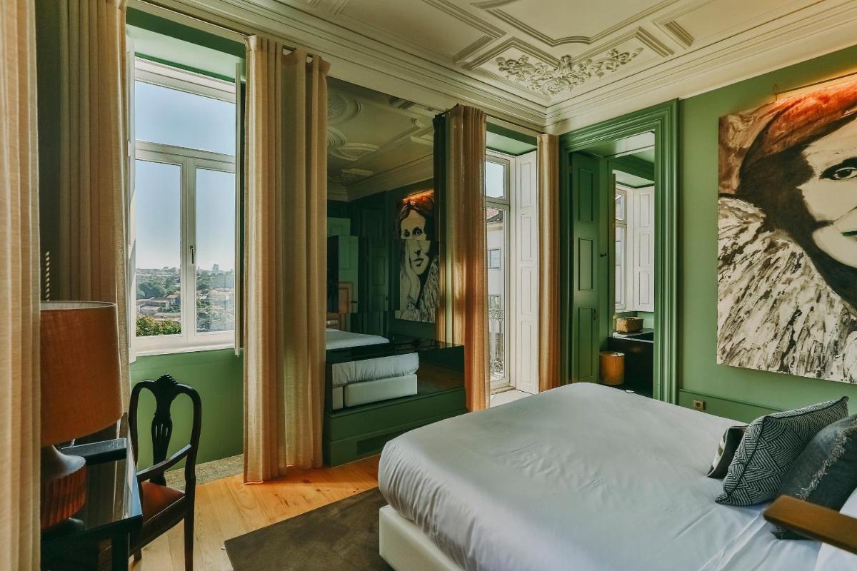 um quarto com paredes verdes e uma cama com uma pintura em Torel Avantgarde no Porto mais 84 fotografias