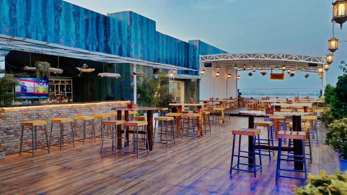a bar with tables and chairs on a wooden deck at Mercure Hyderabad KCP Banjara Hills, An Accor Hotel in Hyderabad a bar with tables and chairs on a wooden deck at Mercure Hyderabad KCP Banjara Hills, An Accor Hotel in Hyderabad