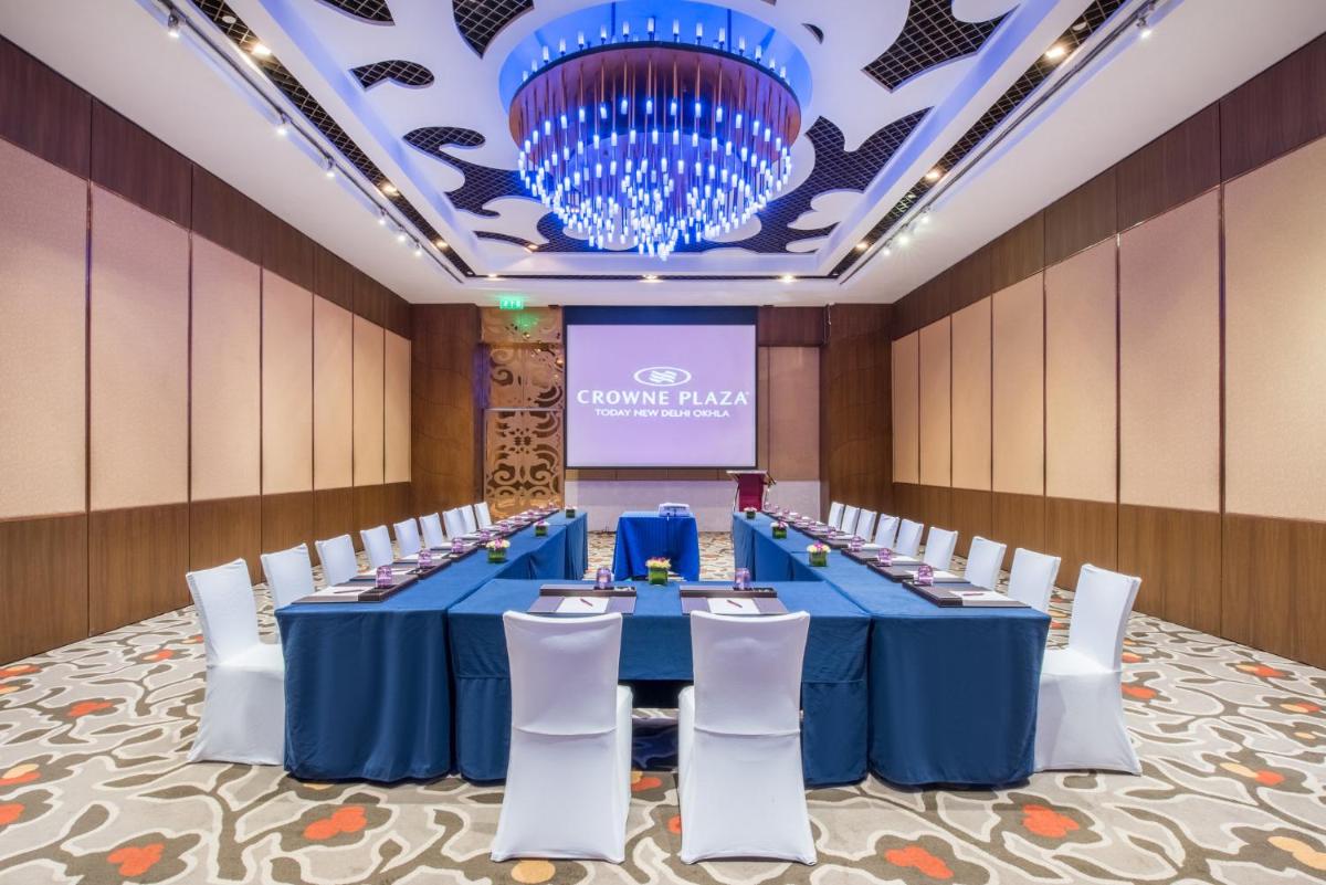 a conference room with a blue table and white chairs at Crowne Plaza New Delhi Okhla by IHG in New Delhi