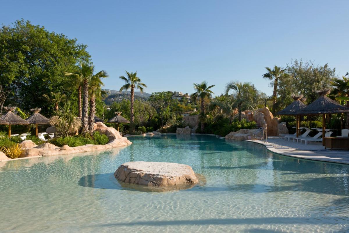 - une piscine dans un complexe avec un rocher dans l'eau dans l'établissement Domaine du Mas De Pierre, à Saint-Paul-de-Vence