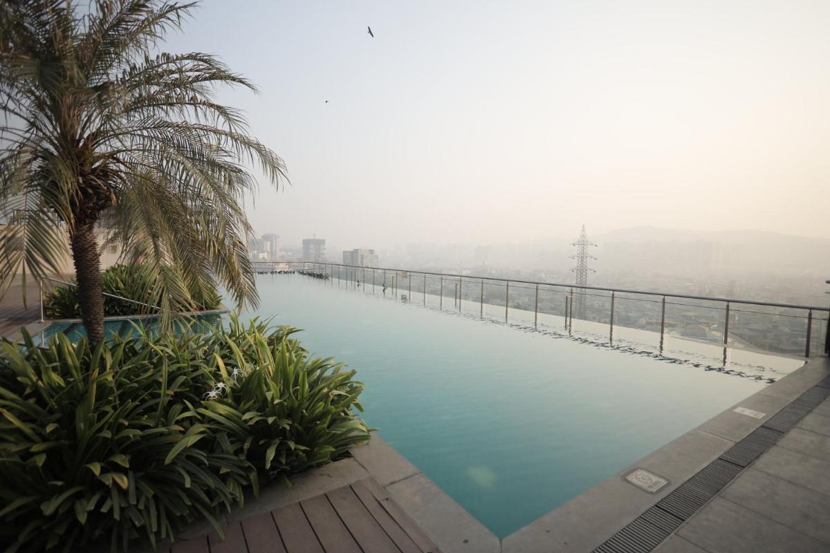 a infinity pool with a view of the city at Holiday Inn Mumbai International Airport by IHG in Mumbai