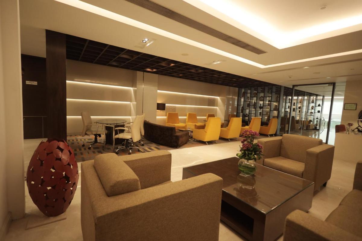 a living room with a couch and a table and chairs at Holiday Inn Mumbai International Airport by IHG in Mumbai