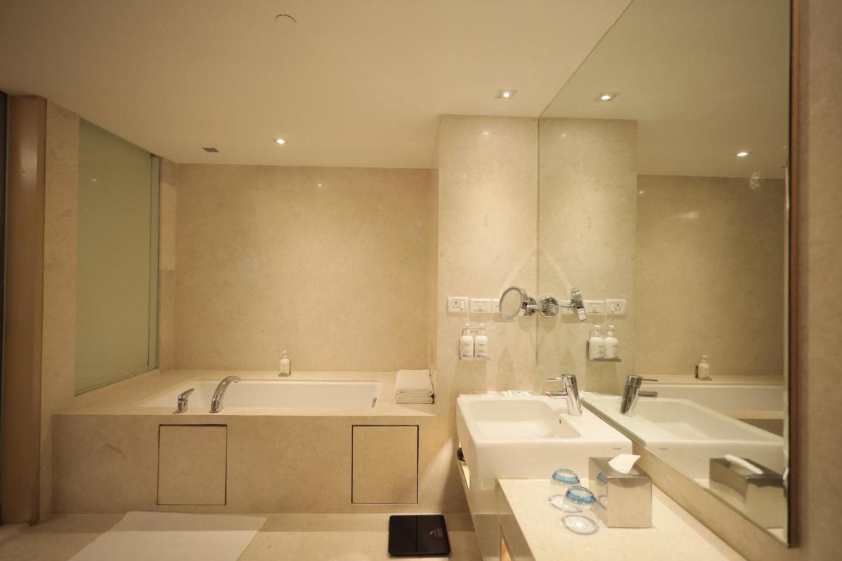 a bathroom with two sinks and a bath tub and a tubermott at Holiday Inn Mumbai International Airport by IHG in Mumbai