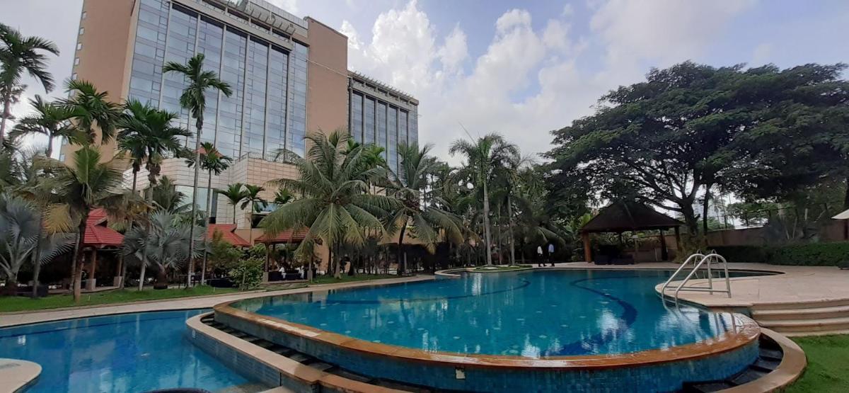 a large swimming pool in front of a building at Crowne Plaza Kochi by IHG in Cochin