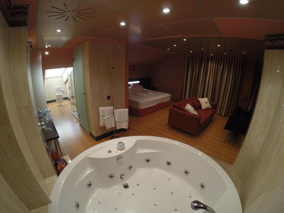 Un baño con bañera y un dormitorio. en Gran Hotel Liber & Spa Playa Golf, en Noja