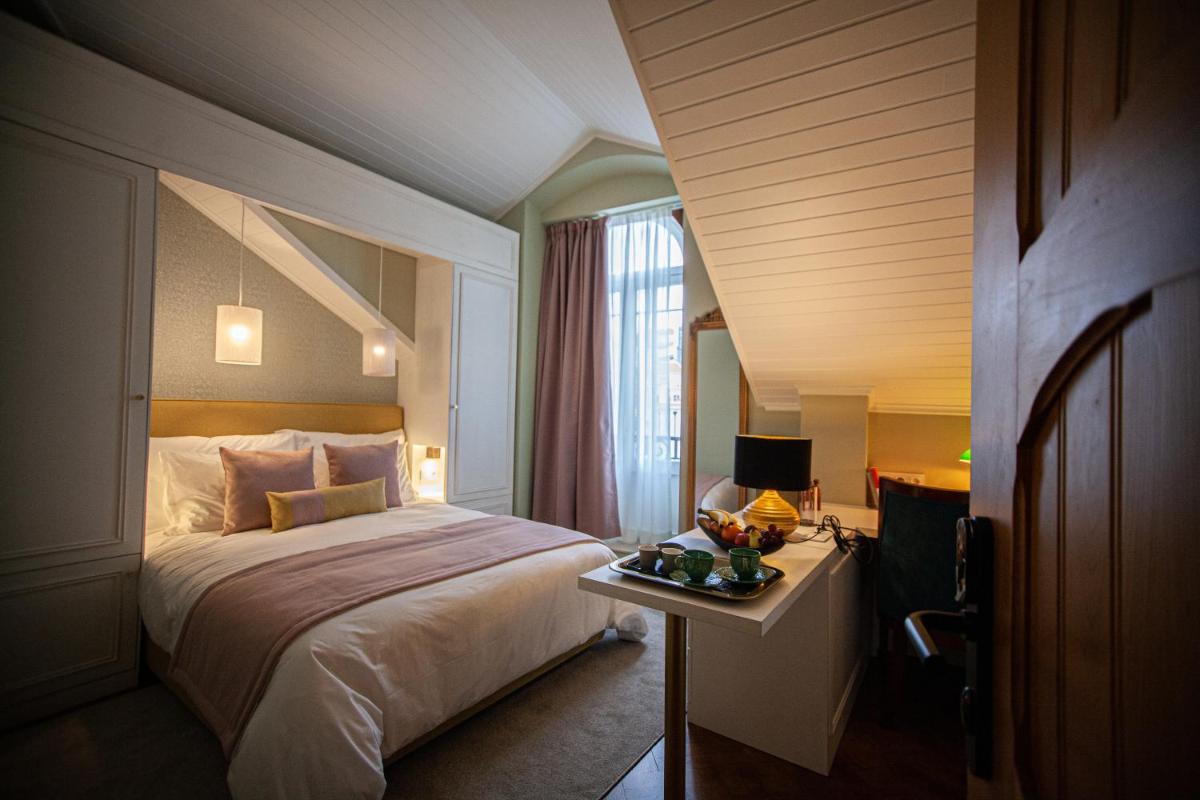 um quarto de hotel com uma cama e uma mesa com um prato de comida em Storytellers Palace em São Martinho do Porto mais 69 fotografias