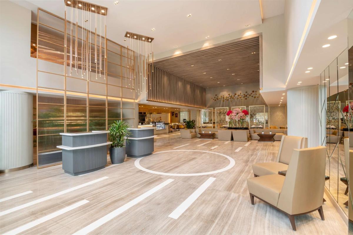 a lobby of a hotel with a reception desk and chairs at Radisson Hotel Sector 29 Gurugram in Gurgaon