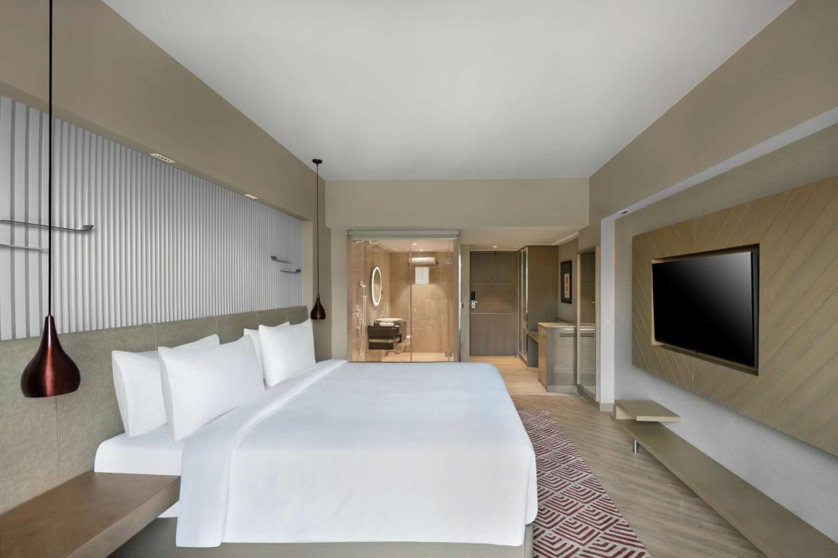 a bedroom with a large white bed and a television at Radisson Hotel Sector 29 Gurugram in Gurgaon