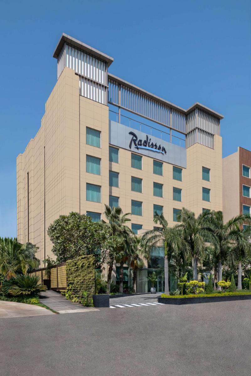 a hotel with a sign on the front of it at Radisson Hotel Sector 29 Gurugram in Gurgaon a hotel with a sign on the front of it at Radisson Hotel Sector 29 Gurugram in Gurgaon