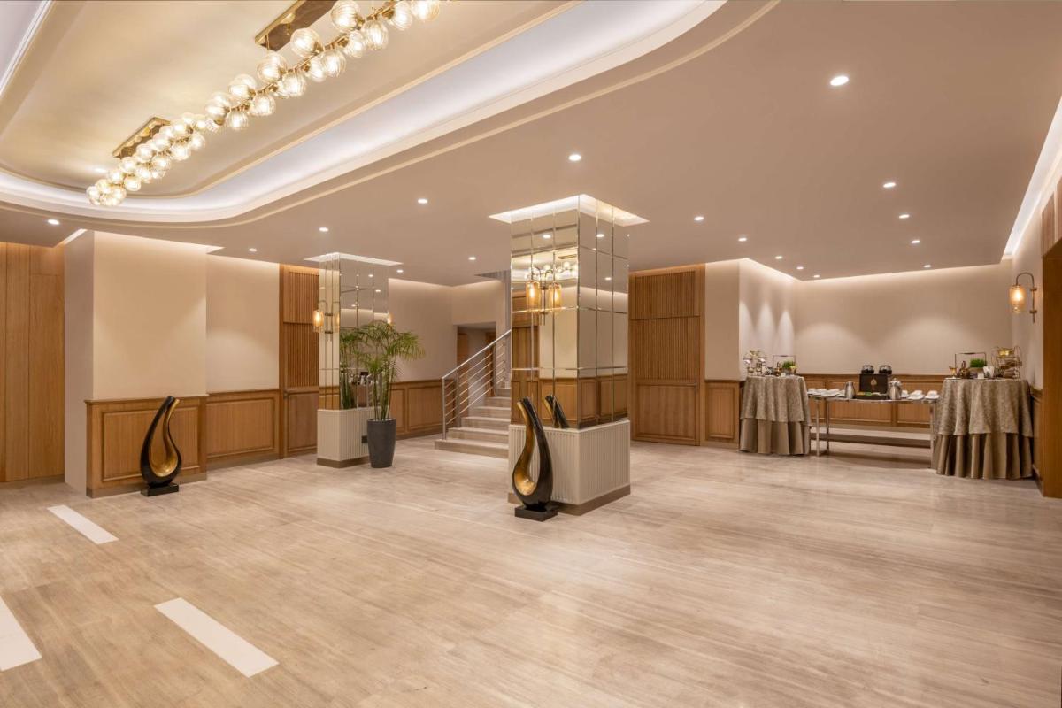 a large lobby with tables and chairs in a building at Radisson Hotel Sector 29 Gurugram in Gurgaon