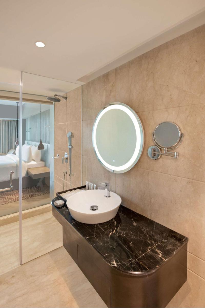 a bathroom with a sink and a mirror at Radisson Hotel Sector 29 Gurugram in Gurgaon a bathroom with a sink and a mirror at Radisson Hotel Sector 29 Gurugram in Gurgaon