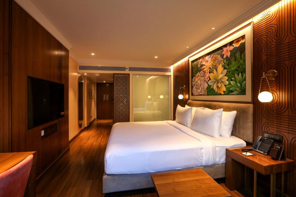 a hotel room with a large bed and a television at Radisson Blu Hotel & Suites GRT Chennai in Chennai