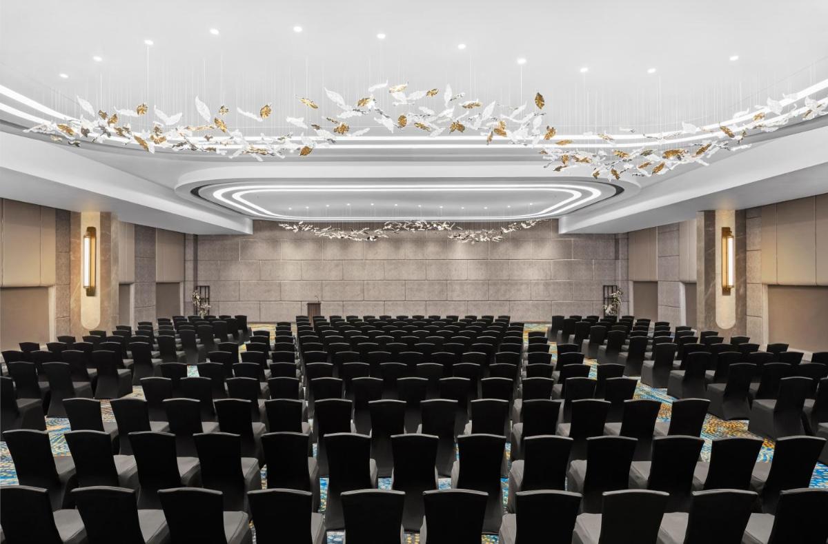 an empty conference room with black chairs and a chandelier at Novotel Mumbai International Airport in Mumbai