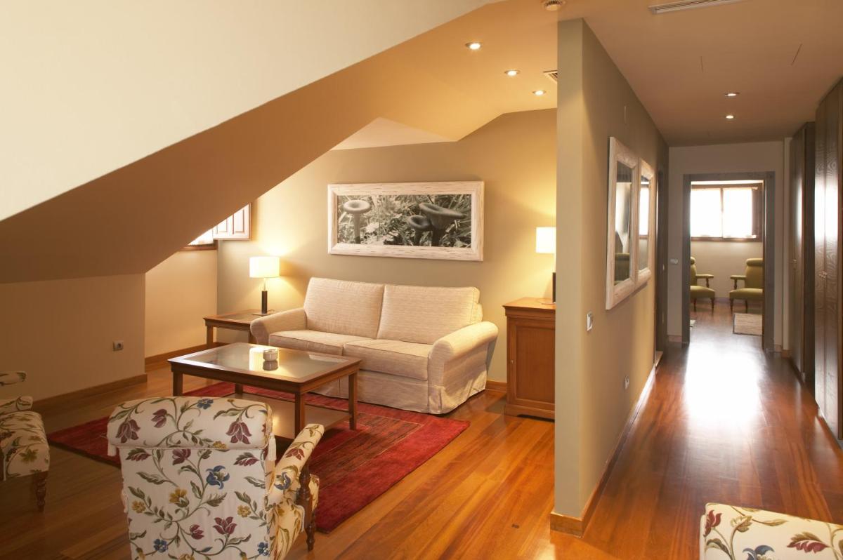 una sala de estar con un sofá y una mesa en Hosteria de Torazo Nature Hotel & Spa, en Torazo