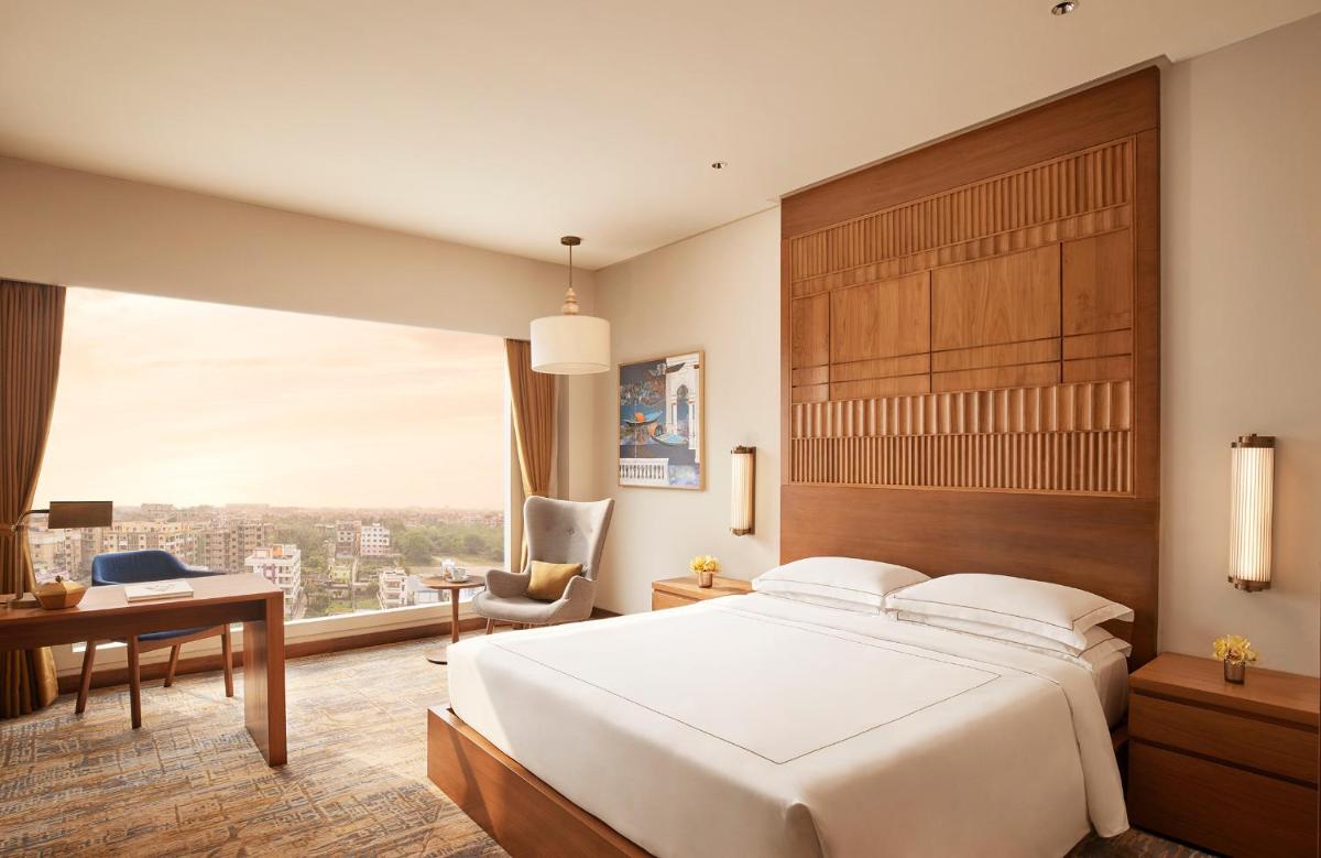 a hotel room with a bed and a desk and a window at Taj City Centre New Town, Kolkata in Kolkata a hotel room with a bed and a desk and a window at Taj City Centre New Town, Kolkata in Kolkata