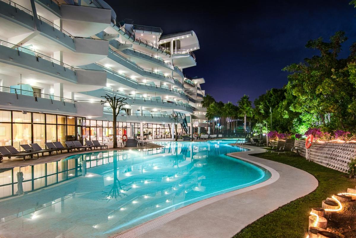 Una piscina frente a un edificio por la noche. en Senator Banus, en Estepona
