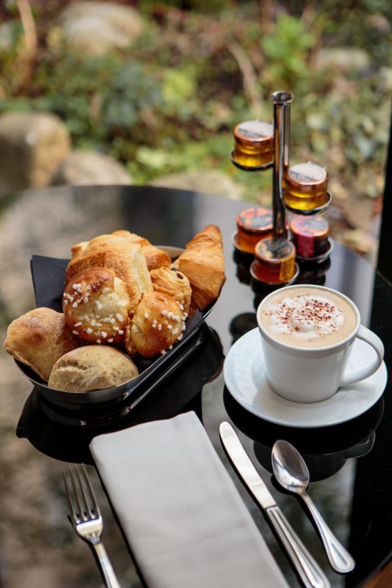 - une table avec un plateau de pâtisseries et une tasse de café dans l'établissement Hôtel Pont Royal Paris, à Paris