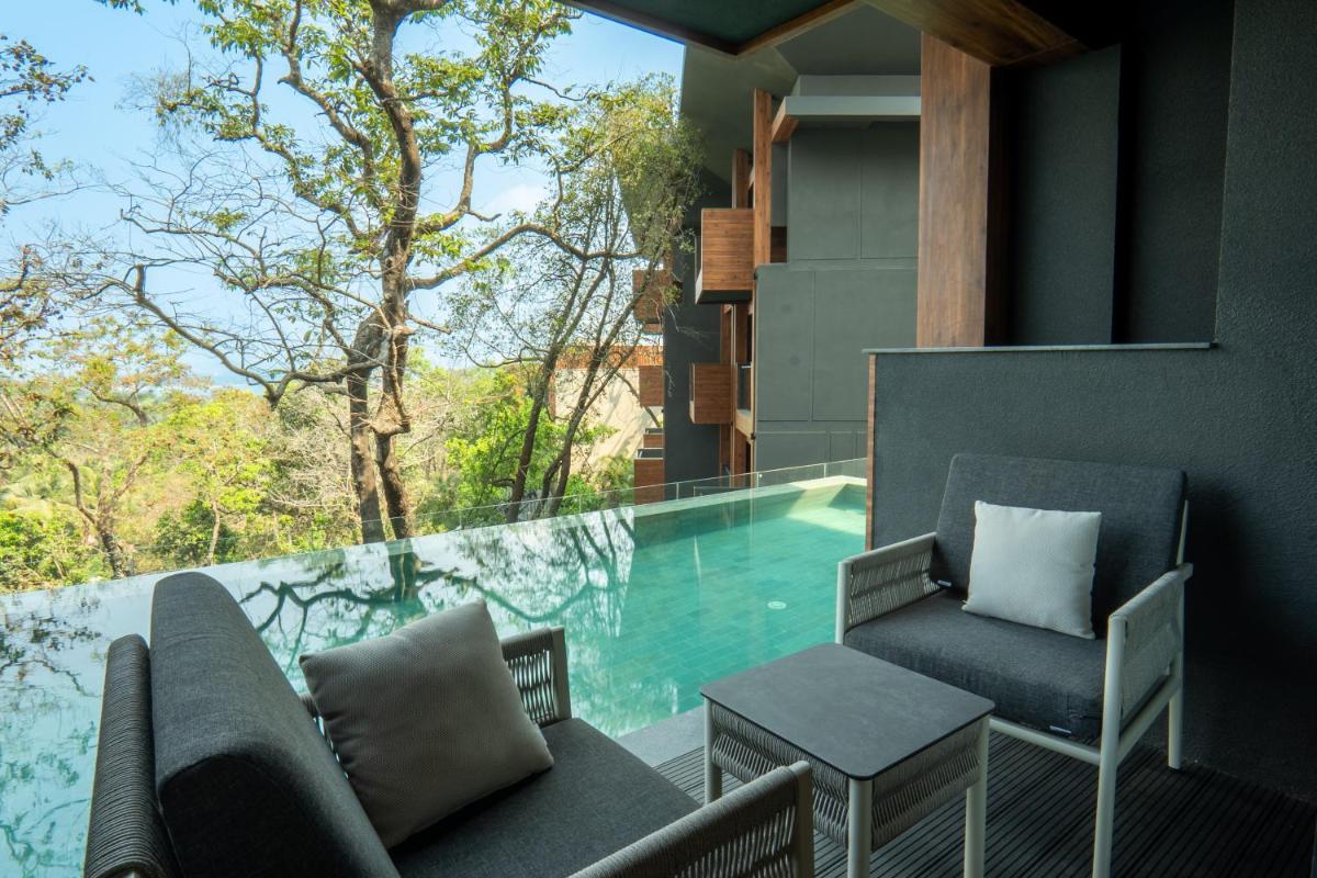 a balcony with a swimming pool and two chairs at JW Marriott Goa in Vagator a balcony with a swimming pool and two chairs at JW Marriott Goa in Vagator