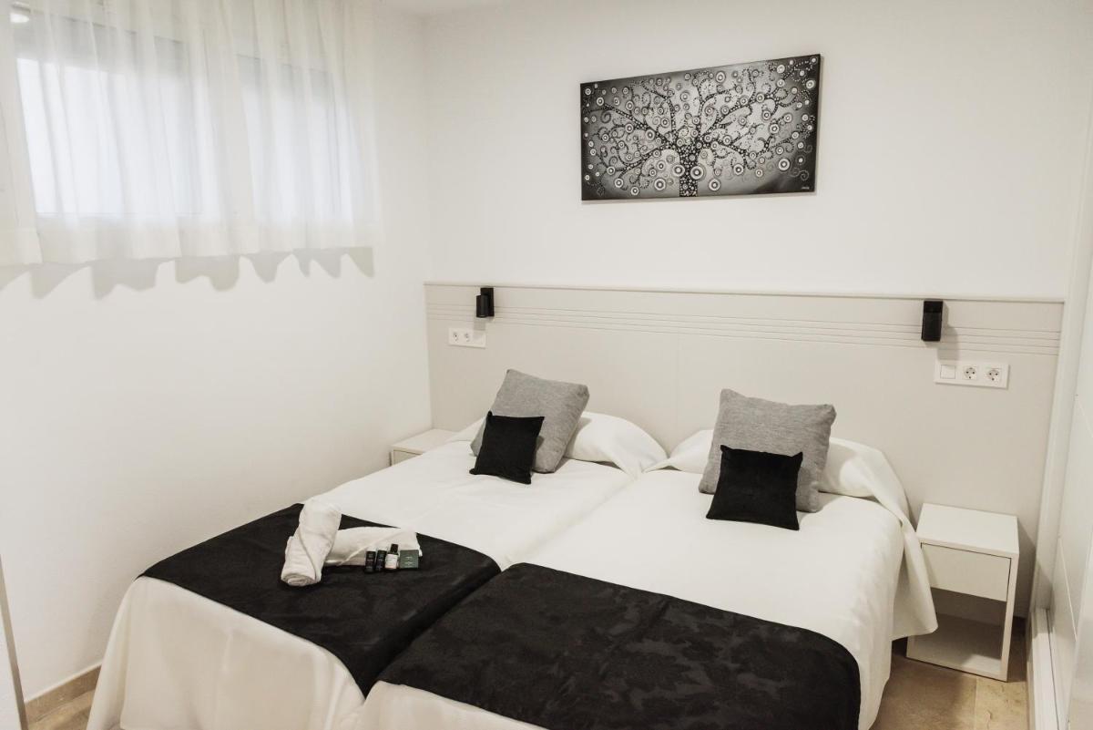Dos camas en una habitación con paredes blancas. en Nacavi Albir Aparthotel, en Albir