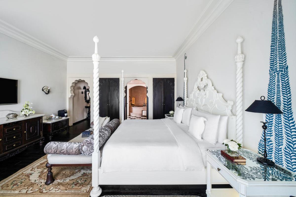 a bedroom with a large white bed and a couch at Fairmont Jaipur in Jaipur
