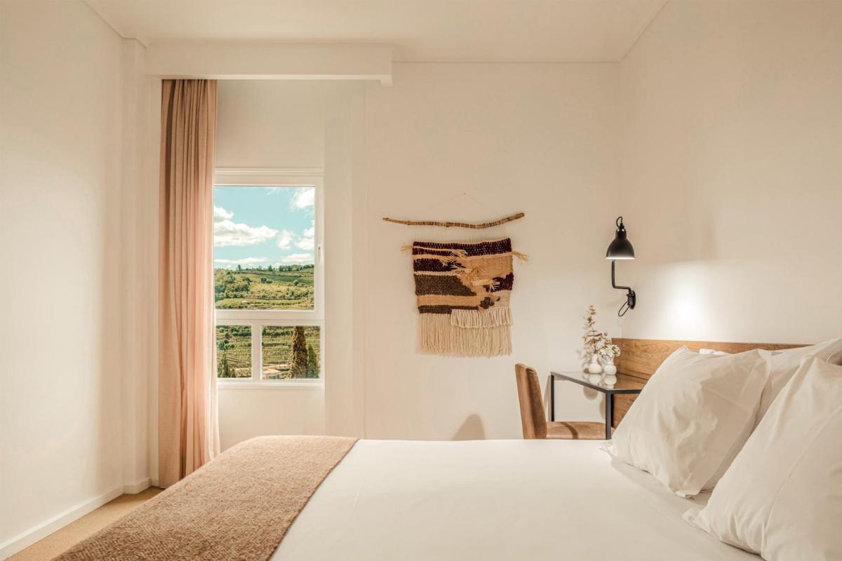 um quarto com uma cama, uma escrivaninha e uma janela em Lamego Hotel & Life em Lamego