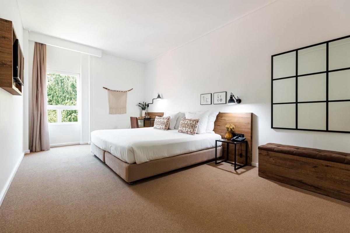 Um quarto branco com uma cama e uma janela. em Lamego Hotel & Life em Lamego mais 44 fotografias