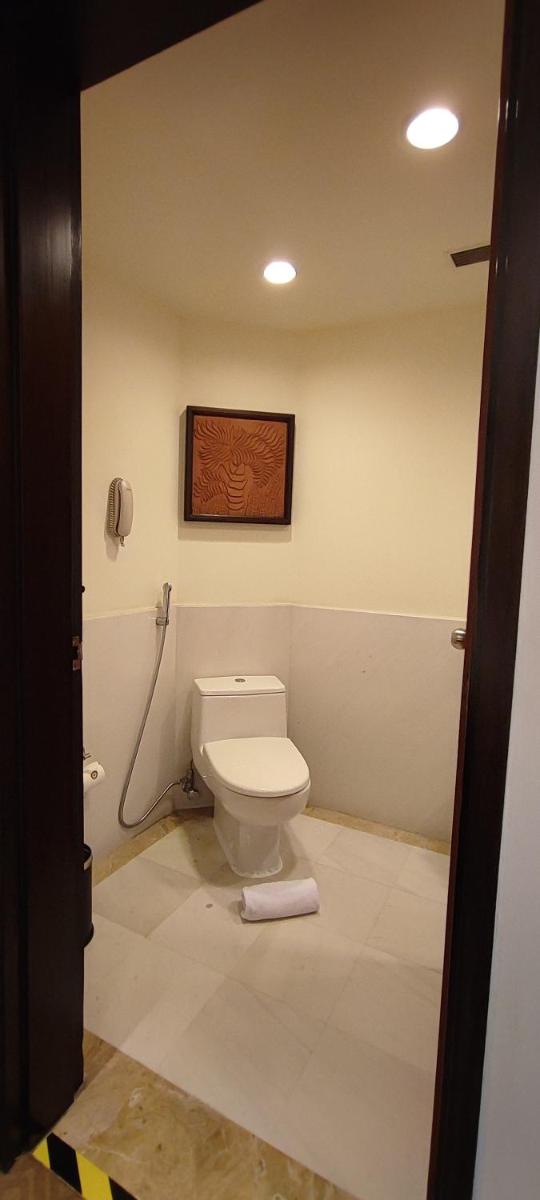 a bathroom with a toilet and a phone on the wall at Taj Bengal in Kolkata
