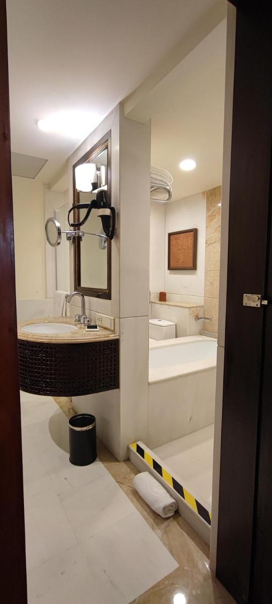 a bathroom with a sink and a bath tub at Taj Bengal in Kolkata
