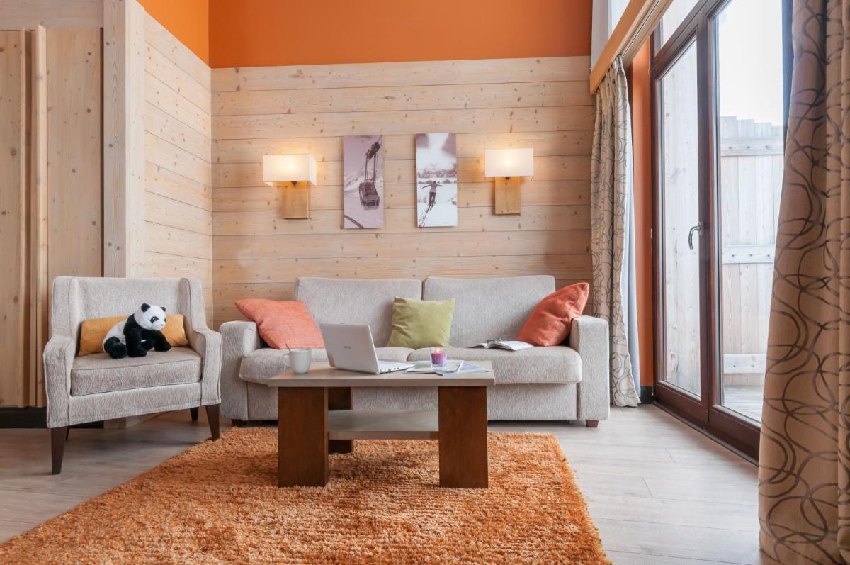 un salon avec un canapé et une table avec un ordinateur portable dans l'établissement Résidence Pierre & Vacances Premium L'Amara, à Avoriaz