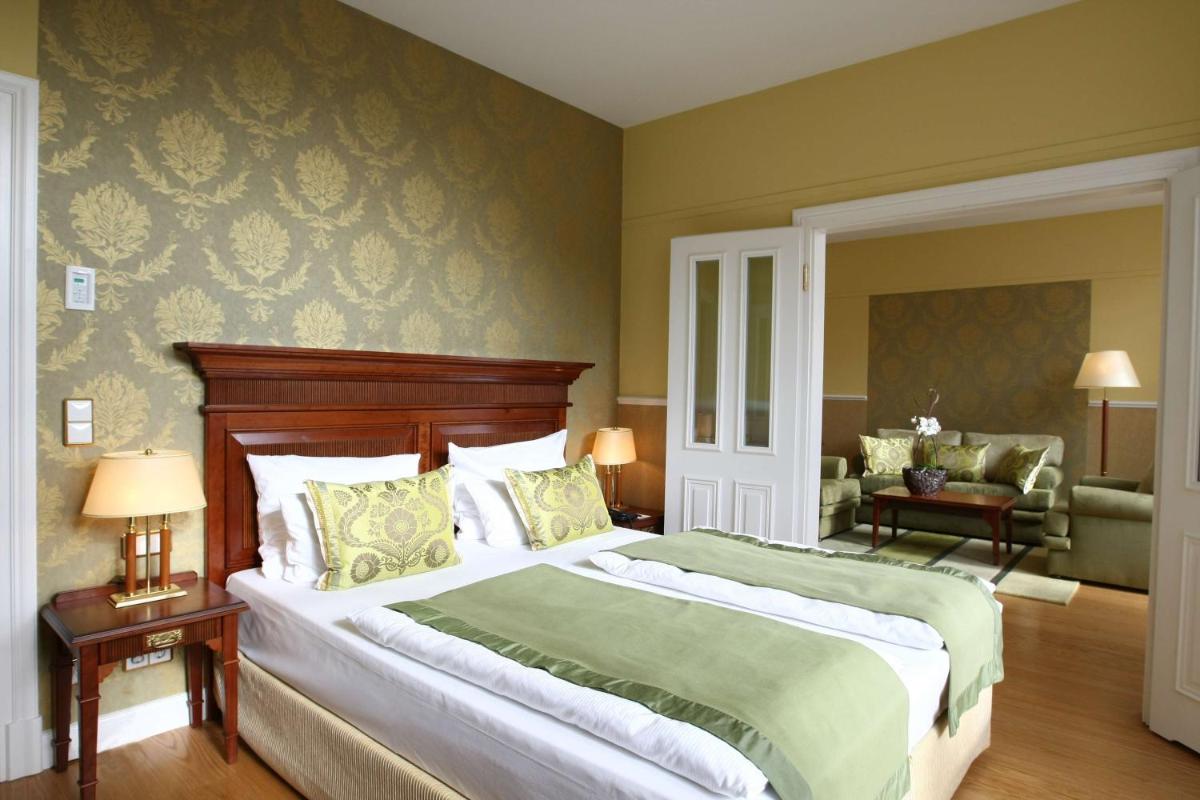 ein Schlafzimmer mit einem großen Bett und ein Wohnzimmer in der Unterkunft ATLANTIC Grand Hotel Travemünde in Travemünde