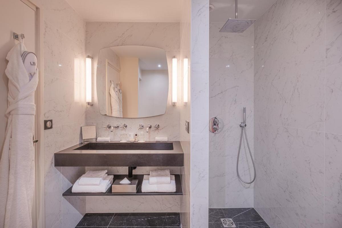 une salle de bain blanche avec un lavabo et une douche dans l'établissement Le Boutique Hotel & Spa, à Bordeaux 37 autres photos