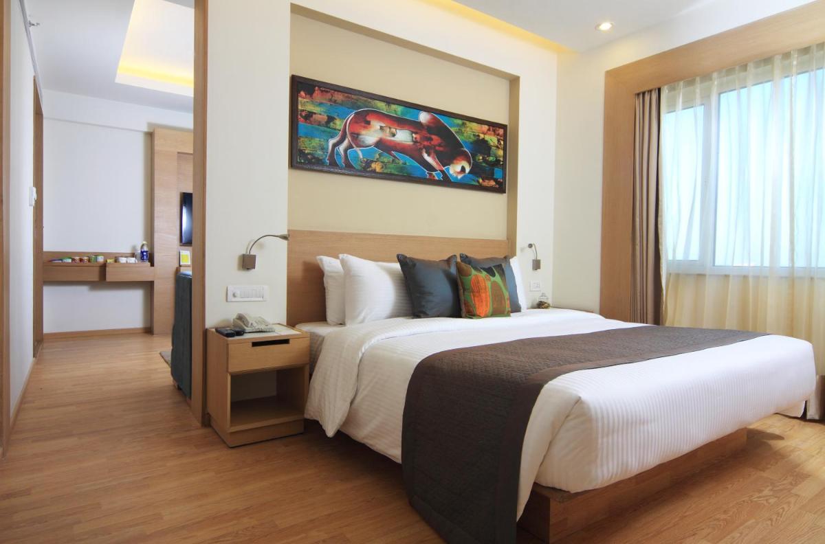 a hotel room with a large bed and a window at Lemon Tree Premier, Ulsoor Lake, Bengaluru in Bengaluru