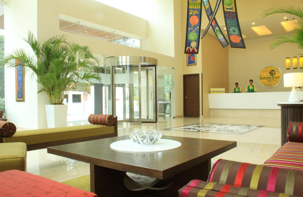a living room with a coffee table and chairs at Lemon Tree Premier, Ulsoor Lake, Bengaluru in Bengaluru