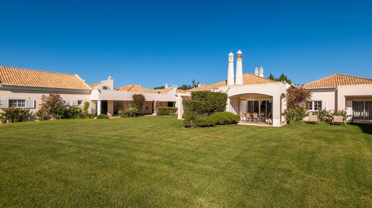 uma casa com um relvado no quintal em Vale d'Oliveiras Quinta Resort & Spa em Carvoeiro
