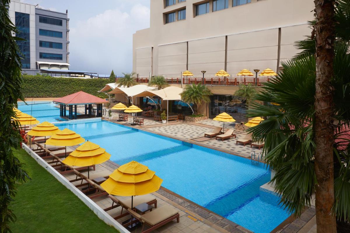 an overhead view of a pool with yellow umbrellas at The Westin Hyderabad Mindspace in Hyderabad