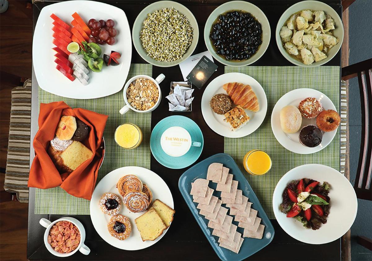 a table with many plates of food on it at The Westin Hyderabad Mindspace in Hyderabad
