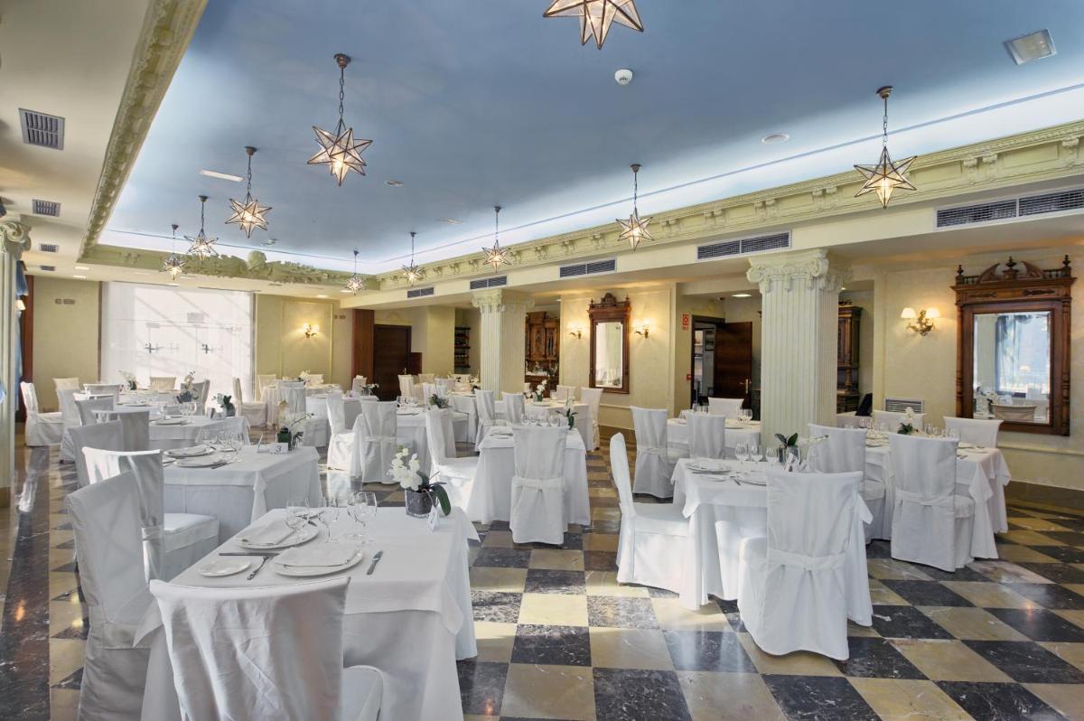 una habitación con mesas y sillas blancas en un edificio en Hotel Balneario La Hermida, en La Hermida 99 fotos más