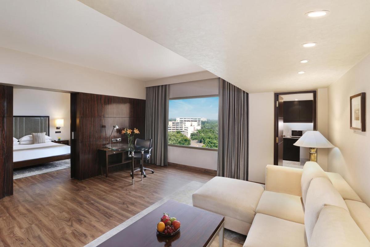 a living room with a couch and a room with a bed at Hyatt Regency Delhi in New Delhi a living room with a couch and a room with a bed at Hyatt Regency Delhi in New Delhi