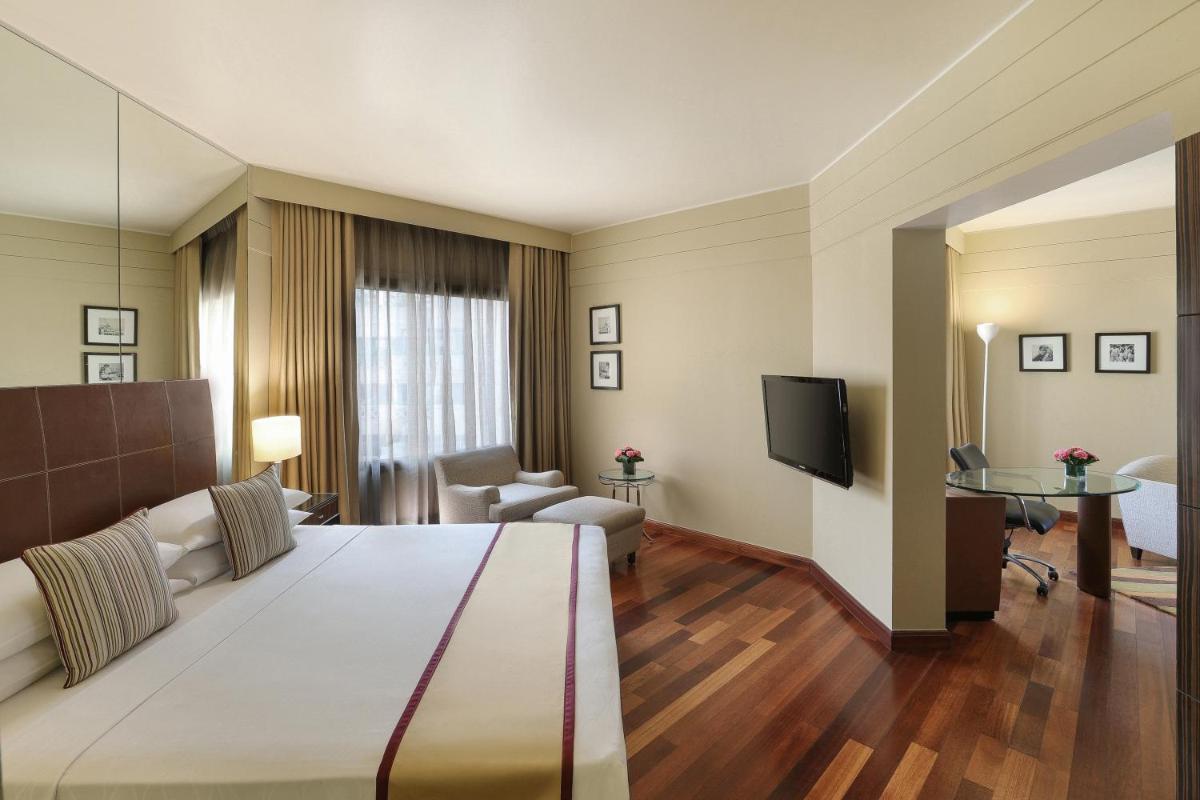 a hotel room with a large bed and a television at Hyatt Regency Delhi in New Delhi a hotel room with a large bed and a television at Hyatt Regency Delhi in New Delhi