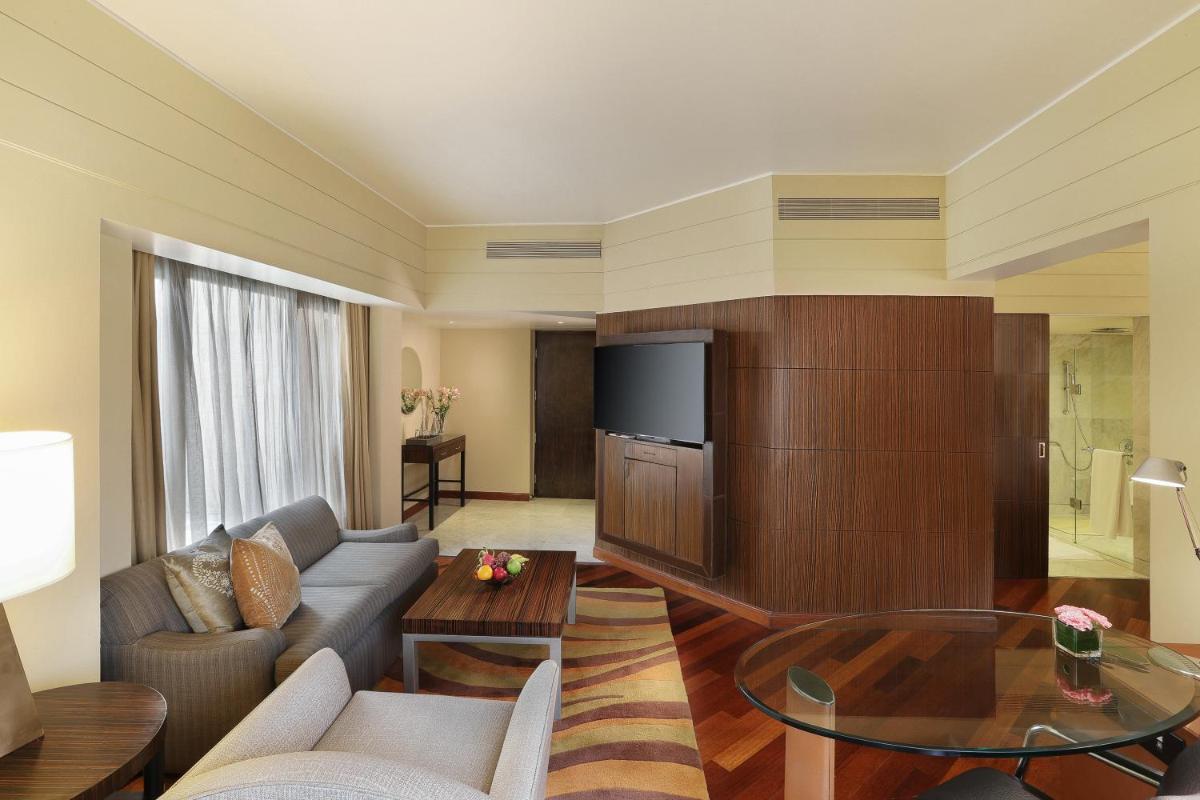 a living room with a couch and a tv at Hyatt Regency Delhi in New Delhi a living room with a couch and a tv at Hyatt Regency Delhi in New Delhi