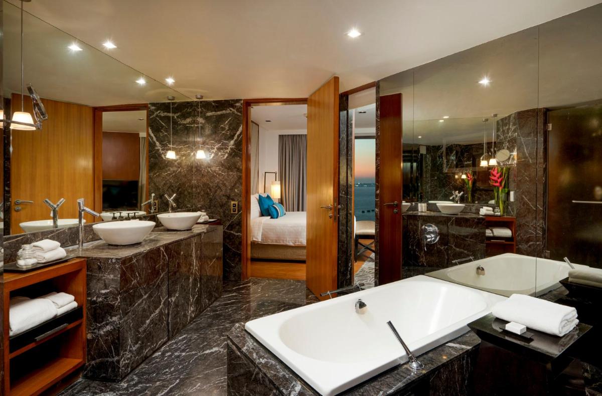 a bathroom with two sinks and a bath tub at InterContinental Marine Drive Mumbai by IHG in Mumbai