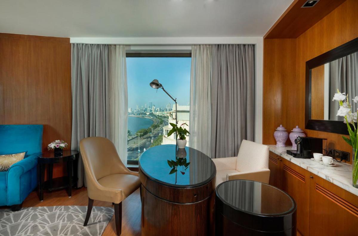 a living room with a table and a room with a view at InterContinental Marine Drive Mumbai by IHG in Mumbai