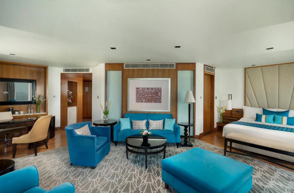 a hotel room with a king sized bed and blue furniture at InterContinental Marine Drive Mumbai by IHG in Mumbai