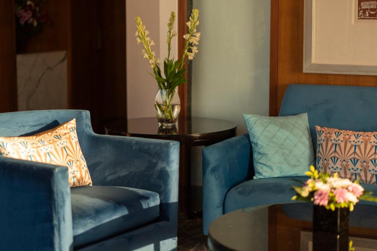 two blue chairs and a table with a vase of flowers at InterContinental Marine Drive Mumbai by IHG in Mumbai