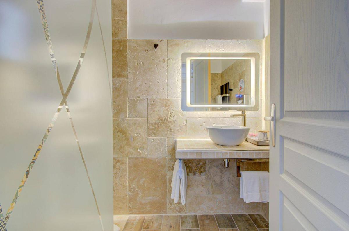 une salle de bain avec un lavabo et un miroir dans l'établissement Hôtel La Palunette, à Saintes-Maries-de-la-Mer